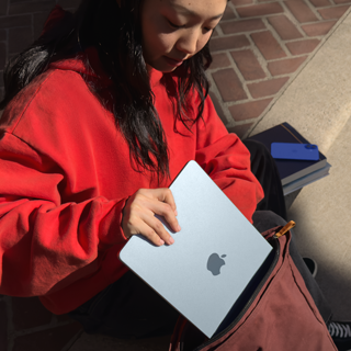 A student placing MacBook Air into their backpack